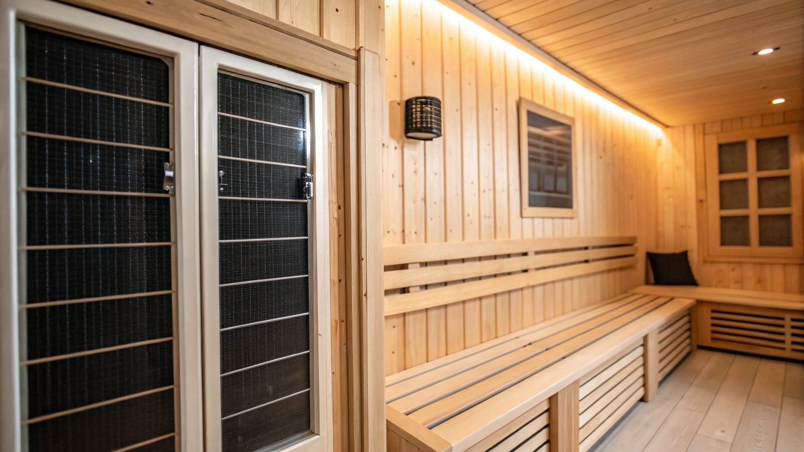 Flat carbon infrared heater panels mounted inside a wooden sauna cabin